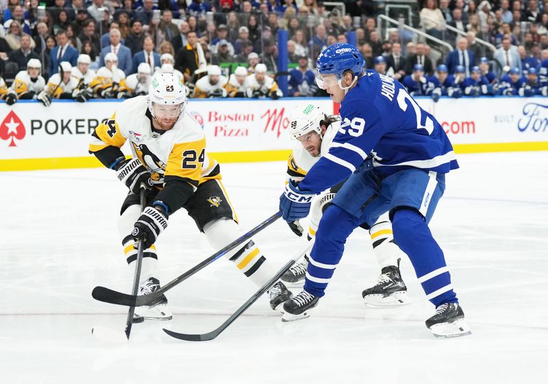 Oct 12, 2024; Toronto, Ontario, CAN; Toronto Maple Leafs right wing Pontus Holmberg (29) battles for the puck with Pittsburgh Penguins defenseman Matt Grzelcyk (24) during the first period at Scotiabank Arena. Mandatory Credit: Nick Turchiaro-Imagn Images