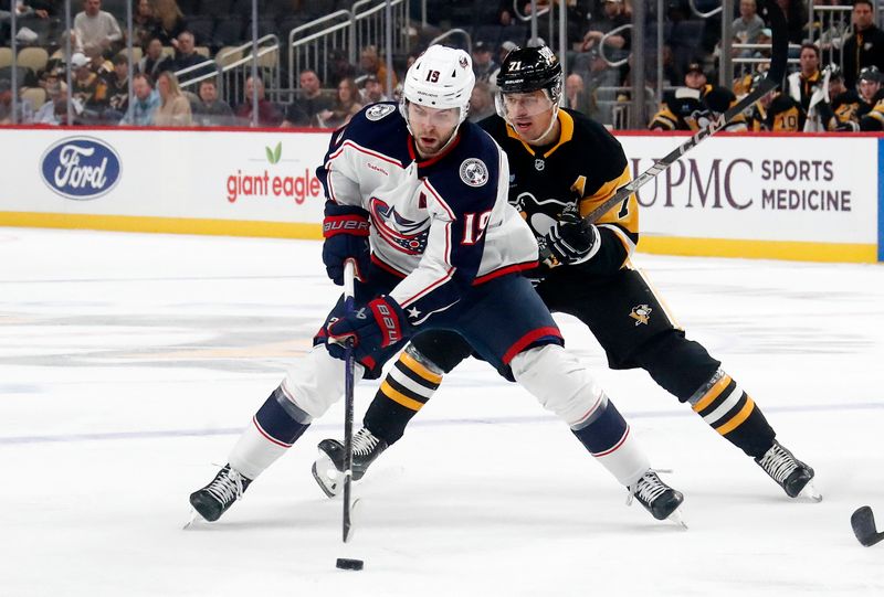 Oct 4, 2024; Pittsburgh, Pennsylvania, USA;  Columbus Blue Jackets center Adam Fantilli (19) skates up ice with the puck ahead of Pittsburgh Penguins center Evgeni Malkin (71) during the second period at PPG Paints Arena. Mandatory Credit: Charles LeClaire-Imagn Images