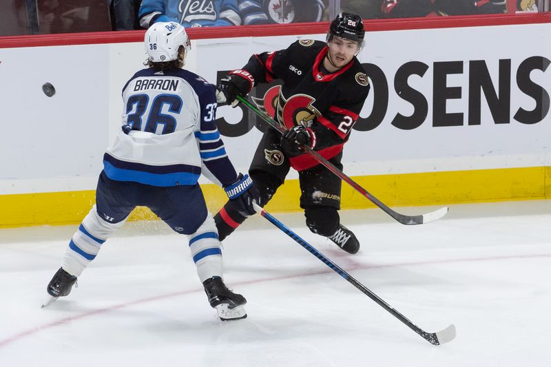 Jan 20, 2024; Ottawa, Ontario, CAN; Ottawa Senators defenseman Erik Brannstrom (26) shoots the puck past Winnipeg Jets center Morgan Barron (36) in the third period at the Canadian Tire Centre. Mandatory Credit: Marc DesRosiers-USA TODAY Sports