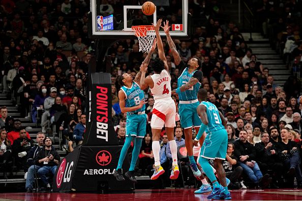 TORONTO, ON - DECEMBER 18: Scottie Barnes #4 of the Toronto Raptors goes to the basket agisntt Nick Smith Jr. #8 and P.J. Washington #25 of the Charlotte Hornets during second half NBA action at Scotiabank Arena on December 18, 2023 in Toronto, Ontario, Canada. NOTE TO USER: User expressly acknowledges and agrees that, by downloading and/or using this Photograph, user is consenting to the terms and conditions of the Getty Images License Agreement. (Photo by Andrew Lahodynskyj/Getty Images)