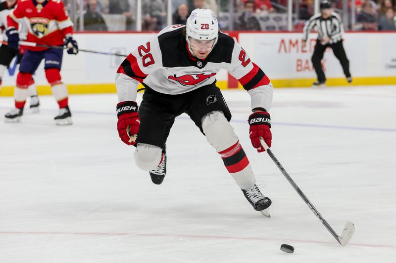 Jan 13, 2024; Sunrise, Florida, USA; New Jersey Devils center Michael McLeod (20) moves the puck against the Florida Panthers during the first period at Amerant Bank Arena. Mandatory Credit: Sam Navarro-USA TODAY Sports