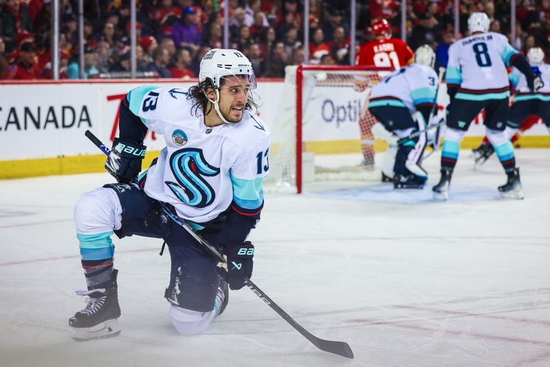 Mar 4, 2024; Calgary, Alberta, CAN; Seattle Kraken left wing Brandon Tanev (13) reacts after being hit by the puck during the second period against the Calgary Flames at Scotiabank Saddledome. Mandatory Credit: Sergei Belski-USA TODAY Sports