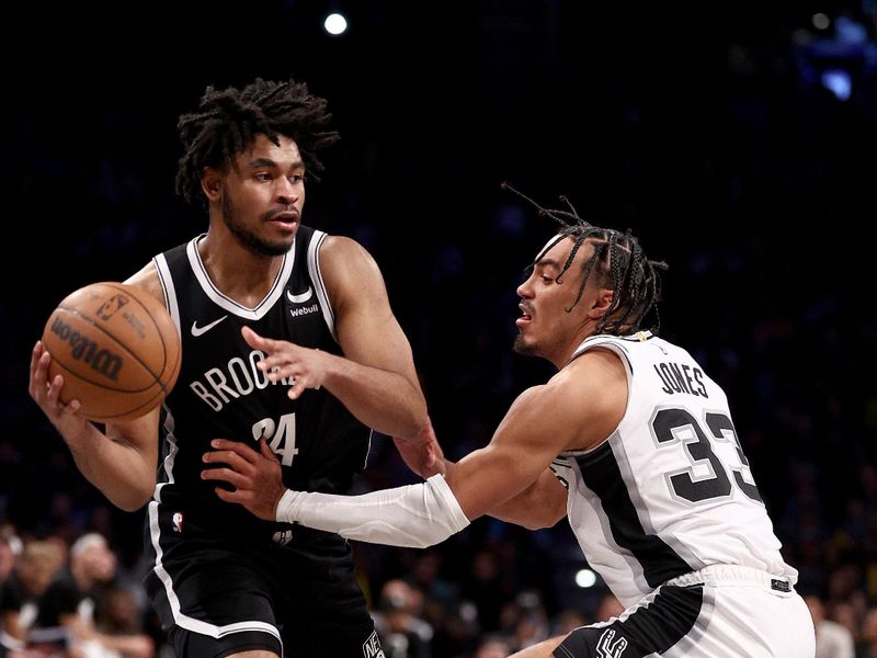 NEW YORK, NEW YORK - FEBRUARY 10: Cam Thomas #24 of the Brooklyn Nets tries to get past Tre Jones #33 of the San Antonio Spurs at Barclays Center on February 10, 2024 in the Brooklyn borough of New York City. The Brooklyn Nets defeated the San Antonio Spurs 123-103. NOTE TO USER: User expressly acknowledges and agrees that, by downloading and or using this photograph, User is consenting to the terms and conditions of the Getty Images License Agreement. (Photo by Elsa/Getty Images)