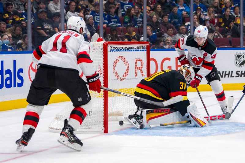 Oct 30, 2024; Vancouver, British Columbia, CAN; New Jersey Devils forward Stefan Noesen (11) watches as forward Jack Hughes (86) scores on Vancouver Canucks goalie Arturs Silovs (31) during the third period at Rogers Arena. Mandatory Credit: Bob Frid-Imagn Images