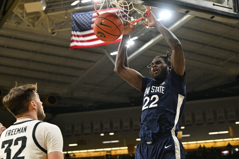 Feb 27, 2024; Iowa City, Iowa, USA; Penn State Nittany Lions forward Qudus Wahab (22) completes a slam dunk as Iowa Hawkeyes forward Owen Freeman (32) looks on during the first half at Carver-Hawkeye Arena. Mandatory Credit: Jeffrey Becker-USA TODAY Sports