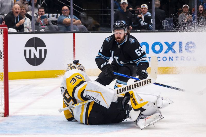 Jan 29, 2025; Salt Lake City, Utah, USA; Utah Hockey Club left wing Michael Carcone (53) watches his shot go over the head of Pittsburgh Penguins goaltender Alex Nedeljkovic (39) for a goal during the second period at Delta Center. Mandatory Credit: Rob Gray-Imagn Images