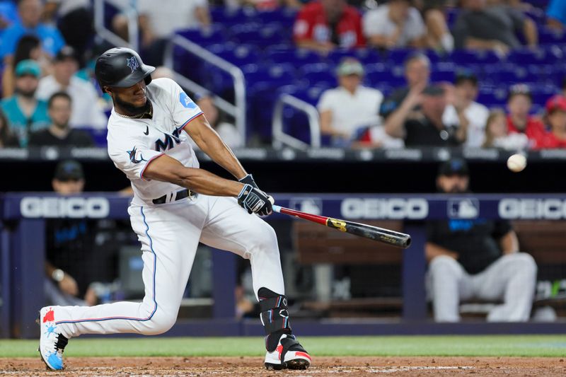 Sep 24, 2023; Miami, Florida, USA; Miami Marlins left fielder Bryan De La Cruz (14) hits a two-run single against the Milwaukee Brewers during the third inning at loanDepot Park. Mandatory Credit: Sam Navarro-USA TODAY Sports