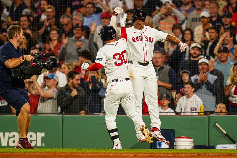 Sep 9, 2024; Boston, Massachusetts, USA; Boston Red Sox right fielder Rob Refsnyder (30) is congratulated by third baseman Rafael Devers (11) after hitting a two run home run against the Baltimore Orioles in the third inning at Fenway Park. Mandatory Credit: David Butler II-Imagn Images