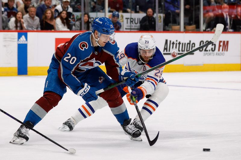 Apr 11, 2023; Denver, Colorado, USA; Colorado Avalanche center Lars Eller (20) and Edmonton Oilers center Leon Draisaitl (29) battle for the puck in the second period at Ball Arena. Mandatory Credit: Isaiah J. Downing-USA TODAY Sports