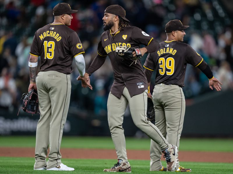 Sep 10, 2024; Seattle, Washington, USA;  San Diego Padres third baseman Manny Machado (13), right fielder Fernando Tatis Jr. (23) and first baseman Donovan Solano (39) celebrate after a game against the Seattle Mariners at T-Mobile Park. Mandatory Credit: Stephen Brashear-Imagn Images