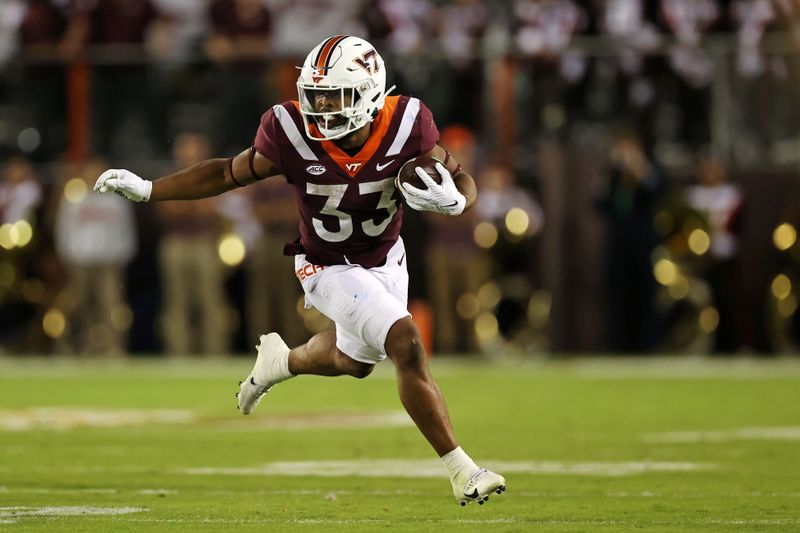 Sep 30, 2023; Blacksburg, Virginia, USA; Virginia Tech Hokies running back Bhayshul Tuten (33) runs the ball during the first quarter against the Pittsburgh Panthers at Lane Stadium. Mandatory Credit: Peter Casey-USA TODAY Sports