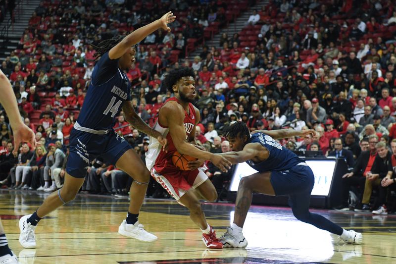 Jan 28, 2023; Las Vegas, Nevada, USA; UNLV Runnin' Rebels guard EJ Harkless (55) drives to the net against Nevada Wolf Pack forward Tre Coleman (14) and guard Kenan Blackshear (13) in the second half at Thomas & Mack Center. Mandatory Credit: Candice Ward-USA TODAY Sports