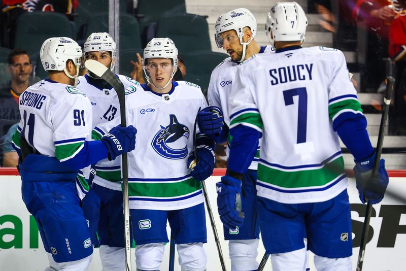 Sep 28, 2024; Calgary, Alberta, CAN; Vancouver Canucks right wing Jonathan Lekkerimaki (23) celebrates his goal with teammates against the Calgary Flames during the first period at Scotiabank Saddledome. Mandatory Credit: Sergei Belski-Imagn Images