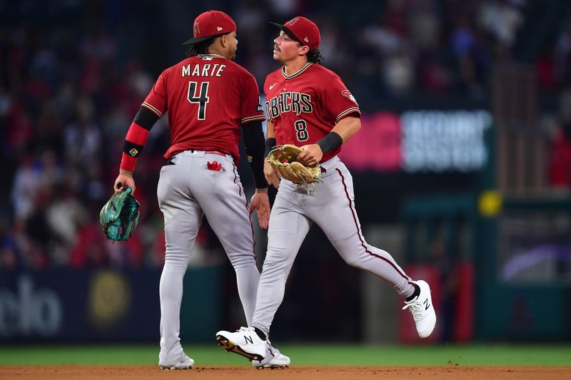 Jul 1, 2023; Anaheim, California, USA; Arizona Diamondbacks second baseman Ketel Marte (4) and center fielder Dominic Fletcher (8) celebrate the victory against the Los Angeles Angels at Angel Stadium. Mandatory Credit: Gary A. Vasquez-USA TODAY Sports