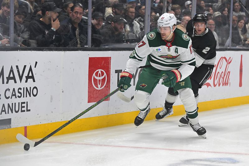 Jan 5, 2026; Los Angeles, California, USA;  Minnesota Wild left wing Marcus Foligno (17) and Los Angeles Kings defenseman Brian Dumoulin (2) chase down the puck in the first period at Crypto.com Arena. Mandatory Credit: Jayne Kamin-Oncea-Imagn Images