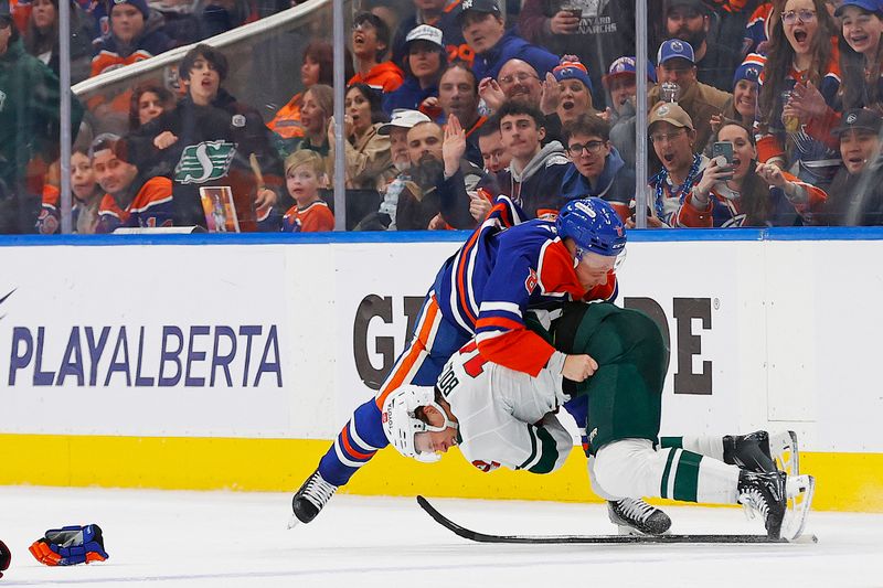 Nov 21, 2024; Edmonton, Alberta, CAN; Edmonton Oilers forward Drake Caggiula (8) fights Minnesota Wild forward Matt Boldy (12) during the second period at Rogers Place. Mandatory Credit: Perry Nelson-Imagn Images