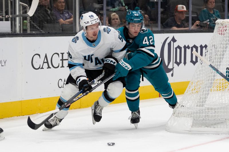 Oct 1, 2024; San Jose, California, USA;  Utah Hockey Club forward Kailer Yamamoto (56) and San Jose Sharks defenseman Luca Cagnoni (42) fight for control of the puck during the third period at SAP Center at San Jose. Mandatory Credit: Stan Szeto-Imagn Images
