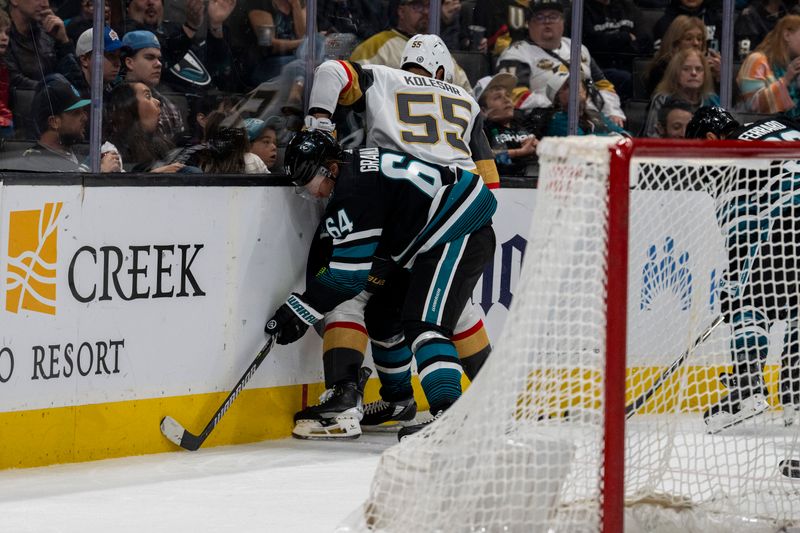 Feb 19, 2024; San Jose, California, USA; Vegas Golden Knights right wing Keegan Kolesar (55) and San Jose Sharks center Mikael Granlund (64) battle for the puck behind the net during the third period at SAP Center at San Jose. Mandatory Credit: Neville E. Guard-USA TODAY Sports