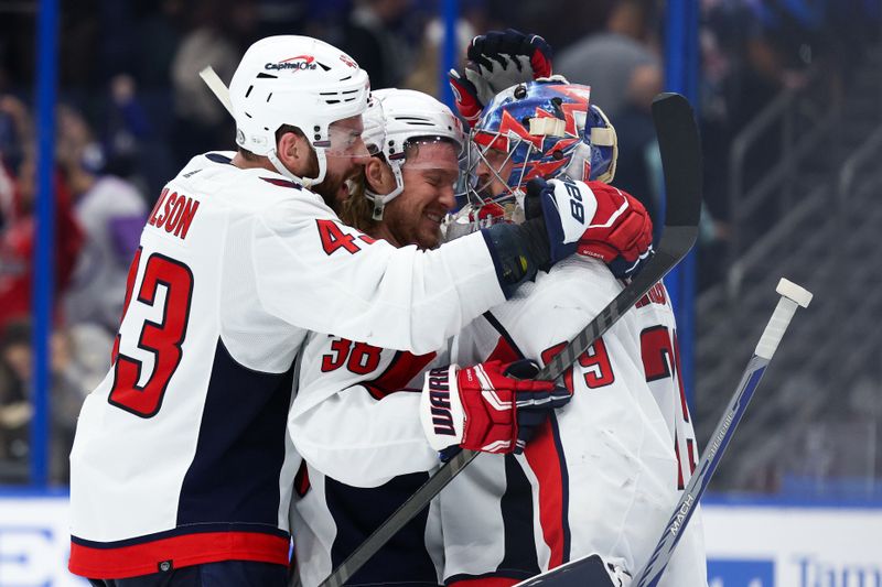 Feb 22, 2024; Tampa, Florida, USA;  Washington Capitals right wing Tom Wilson (43) defenseman Rasmus Sandin (38) and goaltender Charlie Lindgren (79) celebrate after beating the Tampa Bay Lightning at Amalie Arena. Mandatory Credit: Nathan Ray Seebeck-USA TODAY Sports