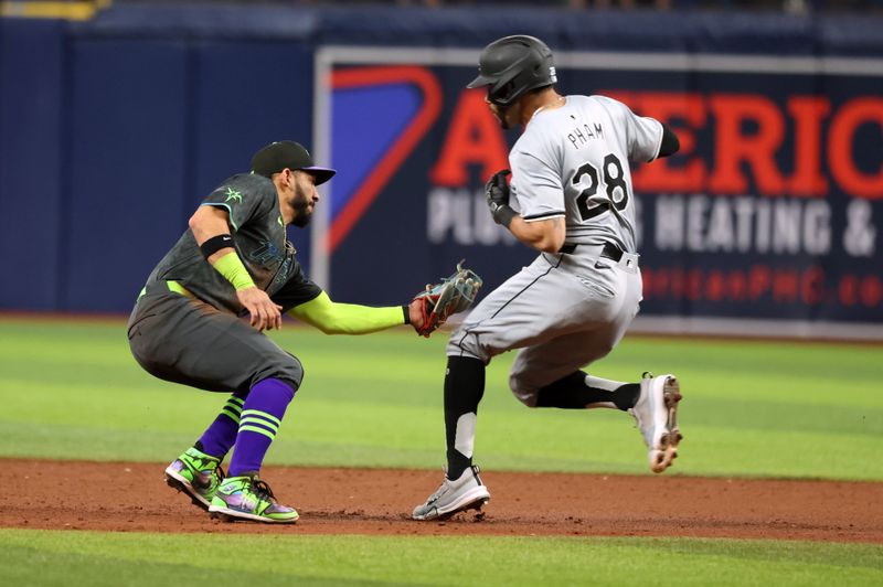 May 8, 2024; St. Petersburg, Florida, USA;  Tampa Bay Rays shortstop Jose Caballero (7) tags out Chicago White Sox outfielder Tommy Pham (28) as he attempts to steal second base during the sixth inning at Tropicana Field. Mandatory Credit: Kim Klement Neitzel-USA TODAY Sports