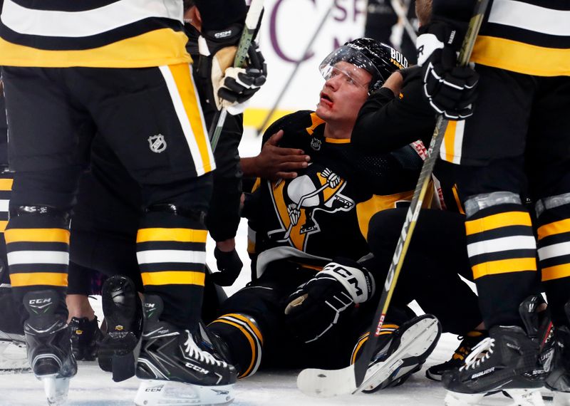 Oct 24, 2023; Pittsburgh, Pennsylvania, USA; Pittsburgh Penguins defenseman John Ludvig (7) is helped into a sitting position after being shaken up on a check against the Dallas Stars during the second period at PPG Paints Arena. Mandatory Credit: Charles LeClaire-USA TODAY Sports