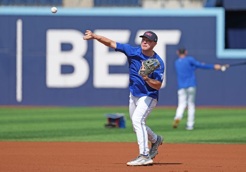 Sep 11, 2024; Toronto, Ontario, CAN; Toronto Blue Jays third baseman Will Wagner (7) throws a ball during batting practice wearing a City of New York Fire Department baseball cap before a game against the New York Mets at Rogers Centre. Mandatory Credit: Nick Turchiaro-Imagn Images