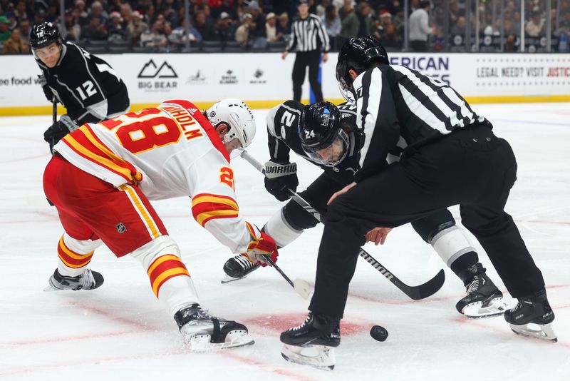 Dec 23, 2023; Los Angeles, California, USA; Los Angeles Kings center Phillip Danault (24) faces off against Calgary Flames center Elias Lindholm (28) during the second period at Crypto.com Arena. Mandatory Credit: Jessica Alcheh-USA TODAY Sports