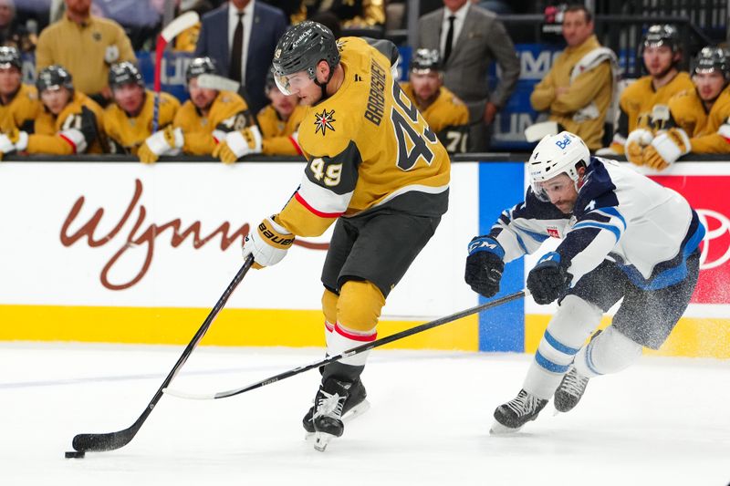 Nov 29, 2024; Las Vegas, Nevada, USA; Vegas Golden Knights center Ivan Barbashev (49) skates ahead of Winnipeg Jets defenseman Neal Pionk (4) during the second period at T-Mobile Arena. Mandatory Credit: Stephen R. Sylvanie-Imagn Images