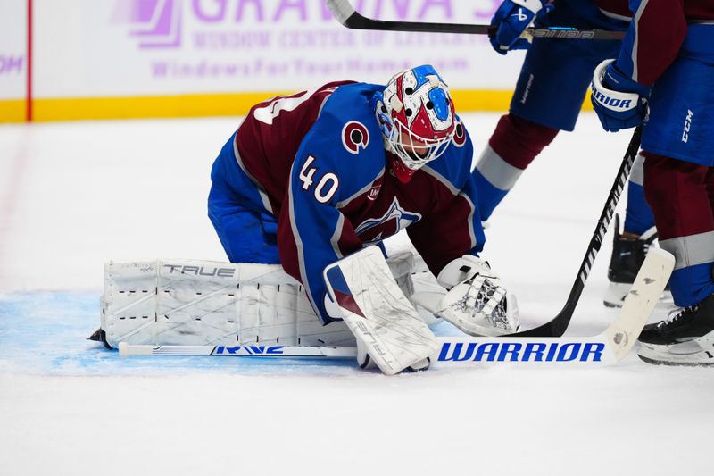 Nov 9, 2024; Denver, Colorado, USA; Colorado Avalanche goaltender Alexandar Georgiev (40) covers the puck against the Carolina Hurricanes at Ball Arena. Mandatory Credit: Ron Chenoy-Imagn Images