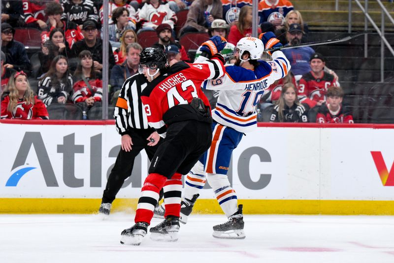 Oct 18, 2025; Newark, New Jersey, USA; New Jersey Devils defenseman Luke Hughes (43) checks Edmonton Oilers center Adam Henrique (19) during the first period at Prudential Center. Mandatory Credit: John Jones-Imagn Images