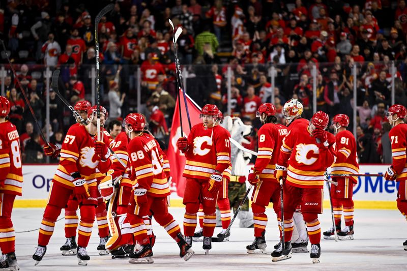 Jan 16, 2024; Calgary, Alberta, CAN; Calgary Flames center Yegor Sharangovich (17) and teammates celebrate after beating the Arizona Coyotes 3-2 in overtime at Scotiabank Saddledome. Mandatory Credit: Brett Holmes-USA TODAY Sports