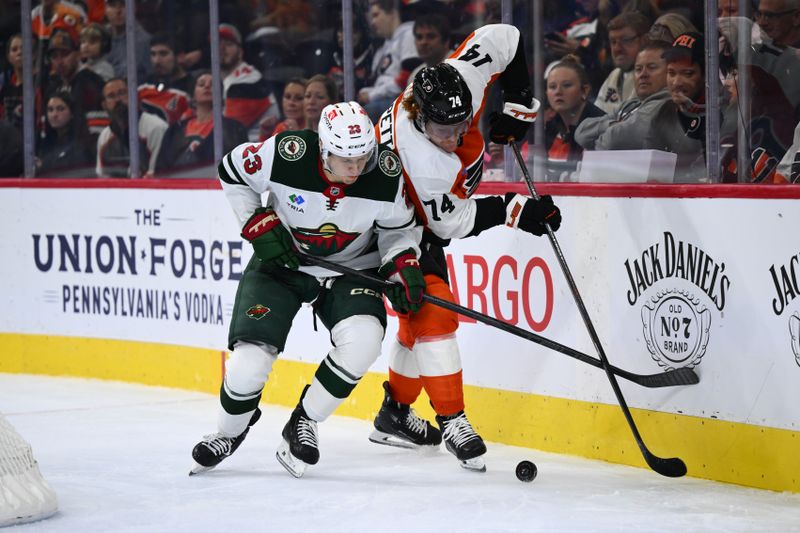 Oct 26, 2024; Philadelphia, Pennsylvania, USA; Minnesota Wild center Marco Rossi (23) and Philadelphia Flyers right wing Owen Tippett (74) battle for the puck in the third period at Wells Fargo Center. Mandatory Credit: Kyle Ross-Imagn Images