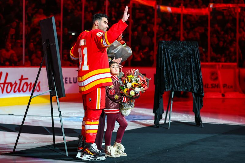 Nov 5, 2025; Calgary, Alberta, CAN; Calgary Flames center Nazem Kadri (91) with his family during ceremony for his 1000th game in the NHL prior to the game against the Columbus Blue Jackets at Scotiabank Saddledome. Mandatory Credit: Sergei Belski-Imagn Images