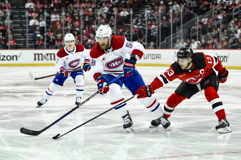 Feb 24, 2024; Newark, New Jersey, USA; Montreal Canadiens defenseman David Savard (58) skates with the puck while being defended by New Jersey Devils center Nico Hischier (13) during the first period at Prudential Center. Mandatory Credit: John Jones-USA TODAY Sports