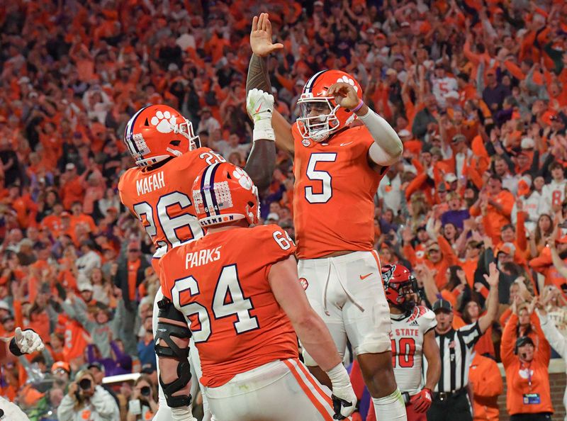 Oct 1, 2022; Clemson, South Carolina, USA;   Clemson quarterback D.J. Uiagalelei (5) celebrates with running back Phil Mafah (26) after a nine-yard touchdown run against NC State during the fourth quarter at Memorial Stadium Mandatory Credit: Ken Ruinard-USA TODAY Sports