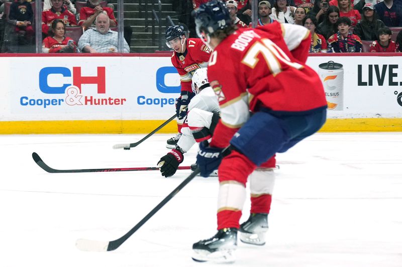 Oct 11, 2025; Sunrise, Florida, USA;  Florida Panthers center Evan Rodrigues (17) looks to pass to center Jesper Boqvist (70) as Ottawa Senators defenseman Thomas Chabot (72) tries to block the pass during the first period at Amerant Bank Arena. Mandatory Credit: Jim Rassol-Imagn Images