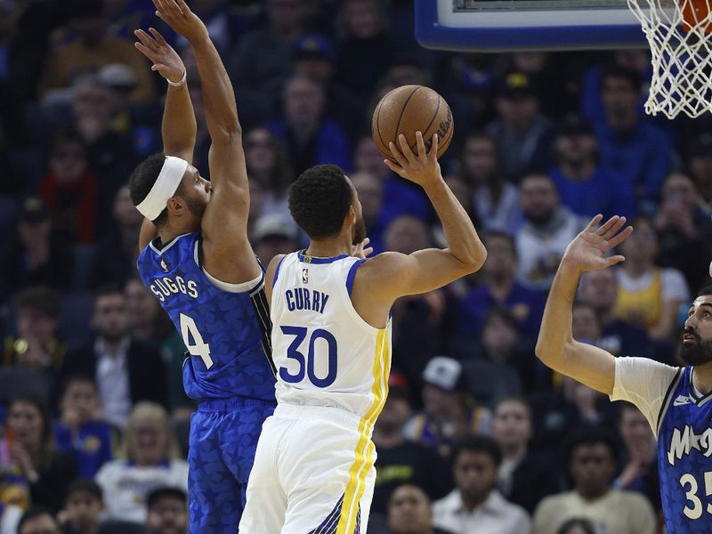 SAN FRANCISCO, CALIFORNIA - JANUARY 02: Stephen Curry #30 of the Golden State Warriors shoots over Jalen Suggs #4 and Goga Bitadze #35 of the Orlando Magic during the first quarter of an NBA basketball game at Chase Center on January 02, 2024 in San Francisco, California. NOTE TO USER: User expressly acknowledges and agrees that, by downloading and or using this photograph, User is consenting to the terms and conditions of the Getty Images License Agreement. (Photo by Thearon W. Henderson/Getty Images)