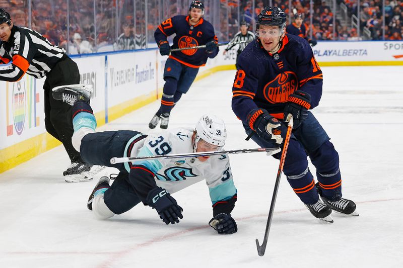 Jan 18, 2024; Edmonton, Alberta, CAN; Edmonton Oilers forward Zach Hyman (18) chips the puck past Seattle Kraken defensemen Ryker Evans (39) during the third period at Rogers Place. Mandatory Credit: Perry Nelson-USA TODAY Sports