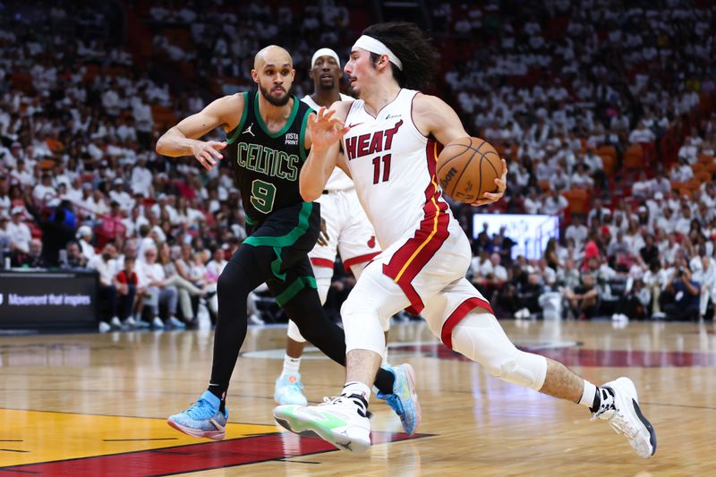 MIAMI, FLORIDA - APRIL 27: Jaime Jaquez Jr. #11 of the Miami Heat drives against Derrick White #9 of the Boston Celtics during the third quarter in game three of the Eastern Conference First Round Playoffs at Kaseya Center on April 27, 2024 in Miami, Florida.  NOTE TO USER: User expressly acknowledges and agrees that, by downloading and or using this photograph, User is consenting to the terms and conditions of the Getty Images License Agreement. (Photo by Megan Briggs/Getty Images)