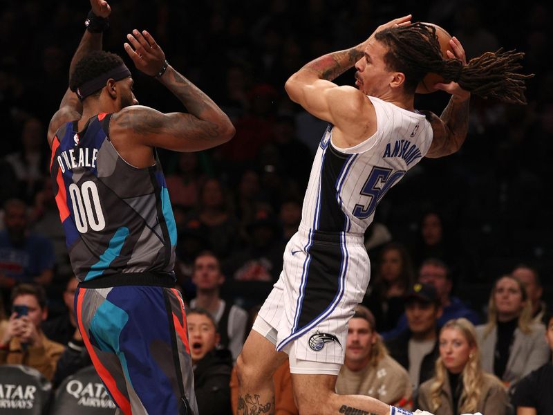 NEW YORK, NEW YORK - DECEMBER 02: Cole Anthony #50 of the Orlando Magic tries to keep the ball in bounds as Royce O'Neale #00 of the Brooklyn Nets defends during the first half at Barclays Center on December 02, 2023 in New York City. NOTE TO USER: User expressly acknowledges and agrees that, by downloading and or using this photograph, User is consenting to the terms and conditions of the Getty Images License Agreement. (Photo by Elsa/Getty Images)