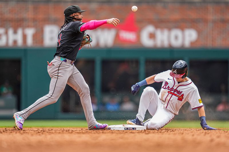 Jun 5, 2025; Cumberland, Georgia, USA; Arizona Diamondbacks second baseman Ketel Marte (4) throws for a double play over Atlanta Braves pinch runner Luke Williams (37) during the ninth inning at Truist Park. Mandatory Credit: Dale Zanine-Imagn Images