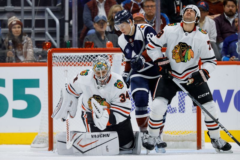 Oct 28, 2024; Denver, Colorado, USA; Chicago Blackhawks defenseman TJ Brodie (78) is high sticked by Colorado Avalanche center Ivan Ivan (82) as Chicago Blackhawks goaltender Petr Mrazek (34) makes a save in the third period at Ball Arena. Mandatory Credit: Isaiah J. Downing-Imagn Images