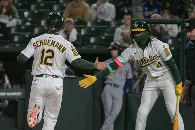 Apr 24, 2025; West Sacramento, California, USA; Athletics third baseman Max Schuemann (12) celebrates with outfielder Lawrence Butler (4) after scoring against the Texas Rangers during the ninth inning at Sutter Health Park. Mandatory Credit: Ed Szczepanski-Imagn Images