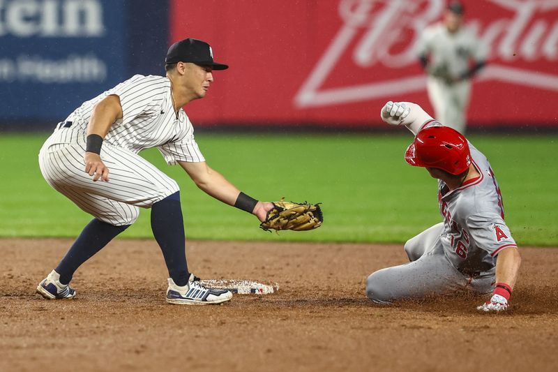 Aug 8, 2024; Bronx, New York, USA;  Los Angeles Angels center fielder Mickey Moniak (16) tries to slide past the tag of New York Yankees shortstop Anthony Volpe (11) in the fifth inning at Yankee Stadium. Mandatory Credit: Wendell Cruz-USA TODAY Sports
