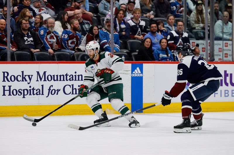 Apr 9, 2024; Denver, Colorado, USA; Minnesota Wild right wing Ryan Hartman (38) controls the puck as Colorado Avalanche defenseman Sean Walker (26) defends in the third period at Ball Arena. Mandatory Credit: Isaiah J. Downing-USA TODAY Sports