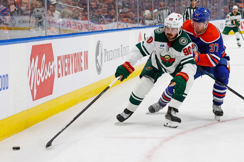 Feb 23, 2024; Edmonton, Alberta, CAN; Minnesota Wild forward Marcus Johansson (90) protects the puck from Edmonton Oilers forward Warren Foegele (37) during the second period at Rogers Place. Mandatory Credit: Perry Nelson-USA TODAY Sports