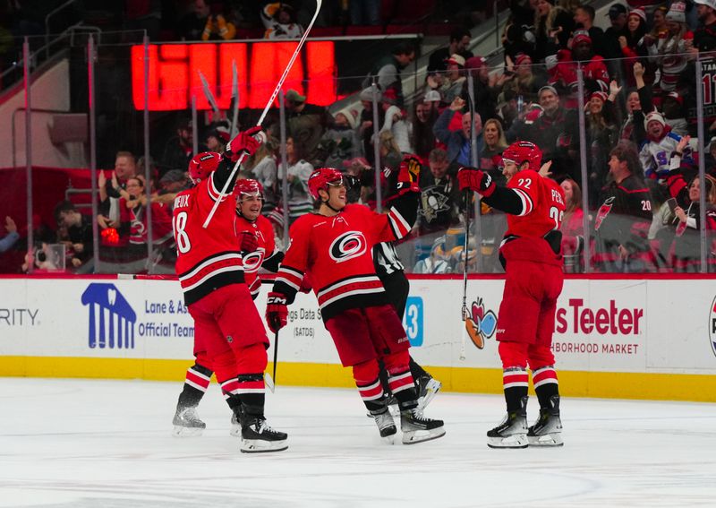 Jan 13, 2024; Raleigh, North Carolina, USA;  Carolina Hurricanes defenseman Brett Pesce (22) celebrates his game winning overtime goal with center Seth Jarvis (24) left wing Teuvo Teravainen (86) and left wing Brendan Lemieux (28) against the Pittsburgh Penguins at PNC Arena. Mandatory Credit: James Guillory-USA TODAY Sports