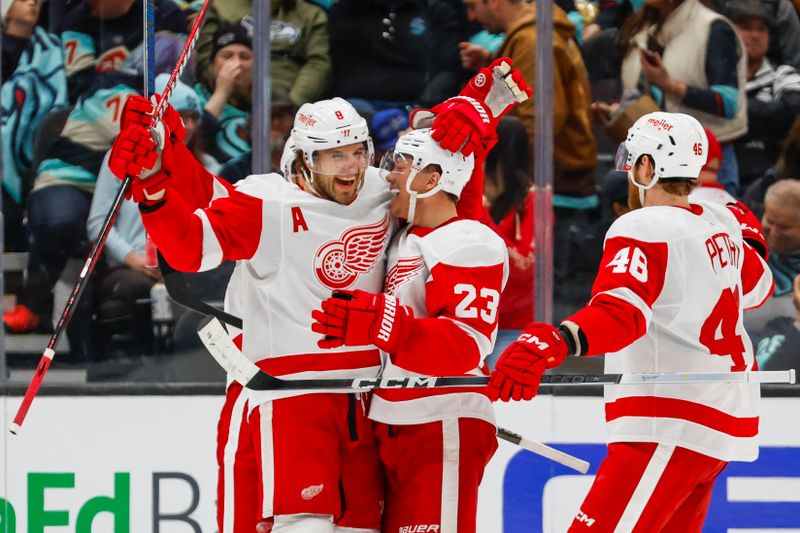 Feb 19, 2024; Seattle, Washington, USA; Seattle Kraken left wing Jared McCann (19) celebrates  with left wing Lucas Raymond (23) after scoring a goal against the Detroit Red Wings during the second period at Climate Pledge Arena. Mandatory Credit: Joe Nicholson-USA TODAY Sports