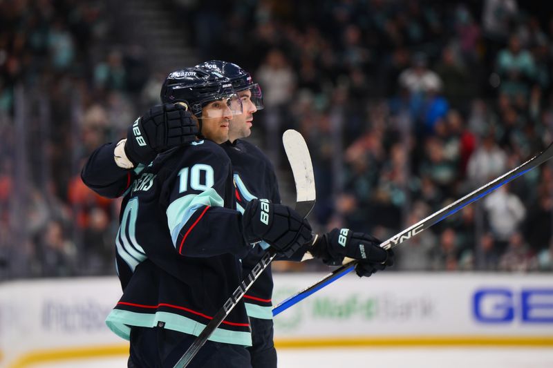 Feb 22, 2024; Seattle, Washington, USA; Seattle Kraken defenseman Justin Schultz (4) and center Matty Beniers (10) celebrate after Schultz scored a goal against the Vancouver Canucks during the second period at Climate Pledge Arena. Mandatory Credit: Steven Bisig-USA TODAY Sports