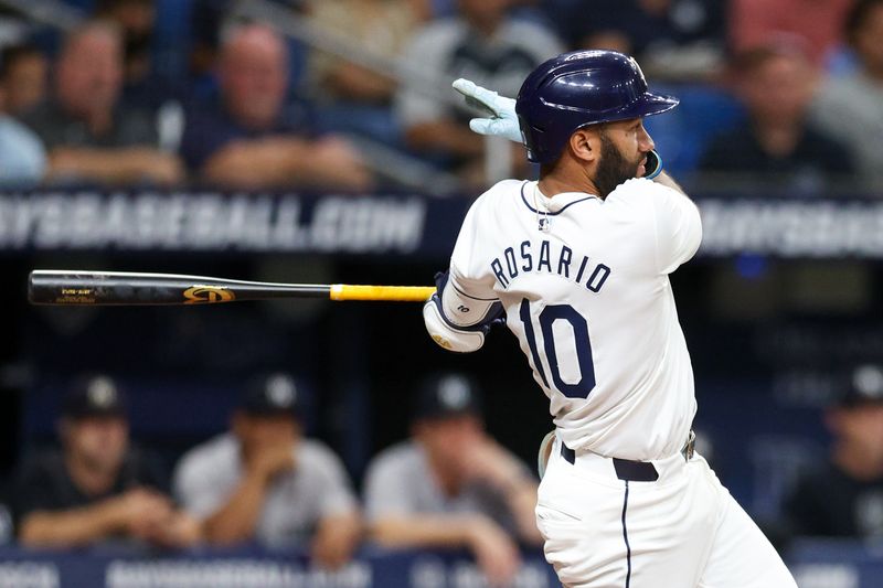 Jul 11, 2024; St. Petersburg, Florida, USA; Tampa Bay Rays second baseman Amed Rosario (10) hits an rbi double against the New York Yankees in the second inning  at Tropicana Field. Mandatory Credit: Nathan Ray Seebeck-USA TODAY Sports